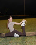 Flare Leggings by Activa Athletics — a model stretching in the Mocha flare leggings