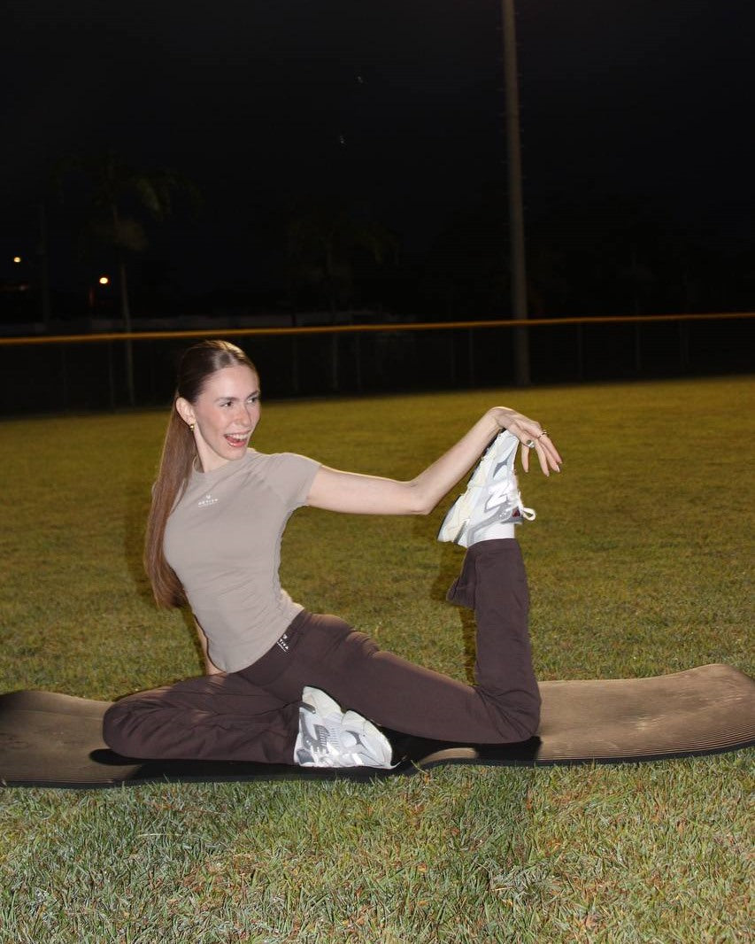 Flare Leggings by Activa Athletics — a model stretching in the Mocha flare leggings